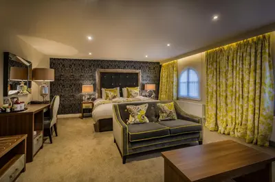 a hotel room with a bed and a couch at The Golden Lion Hotel, St Ives, Cambridgeshire - The Coaching Inn Group in St Ives