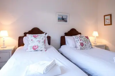 two twin beds in a room with two lamps at Pear Tree Cottage in Aldeburgh