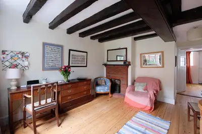 a bedroom with a desk and a chair and a fireplace at Pear Tree Cottage in Aldeburgh