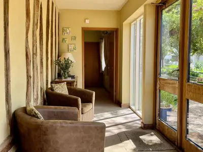 a living room with two chairs and a window at Orchard Cottage in Willingham