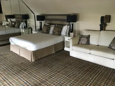 a bedroom with a large bed and a couch at The White Hart in Great Yeldham