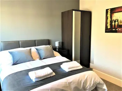 a bedroom with a large bed with two pillows on it at Guineas House in Newmarket