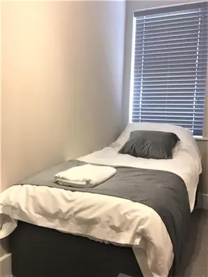 a bed in a room with a pillow and a window at Guineas House in Newmarket