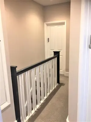 a stairway with a white and black railing at Guineas House in Newmarket