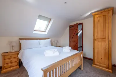 a bedroom with a large white bed and a window at 3 Beach Cottages - Aldeburgh Coastal Cottages in Thorpeness