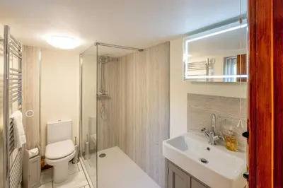 a bathroom with a toilet and a sink and a shower at 3 Beach Cottages - Aldeburgh Coastal Cottages in Thorpeness
