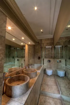 a large bathroom with two sinks and two tubs at Strattons in Swaffham