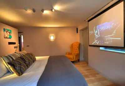 a bedroom with a bed and a tv on the wall at Strattons in Swaffham