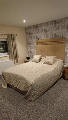 a bedroom with a large bed with pillows on it at Grove House Hotel in Woodbridge