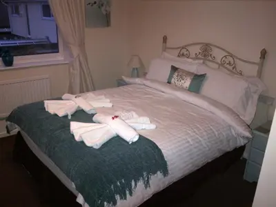 a bedroom with a bed with two towels on it at Grove House Hotel in Woodbridge