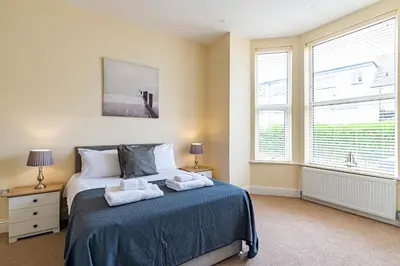 a bedroom with a bed with two towels on it at Greyfriars in Clacton-on-Sea