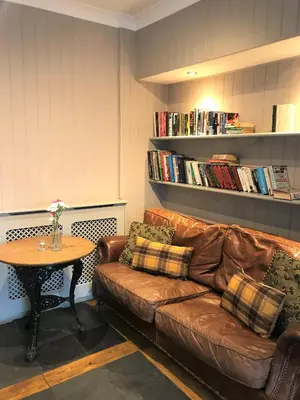 a living room with a brown leather couch and a table at The White Horse Hotel in Leiston