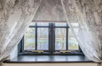 a window with curtains and a view of a yard at Highgate Annexe in Takeley