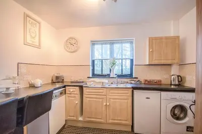 a kitchen with a sink and a washing machine at Highgate Annexe in Takeley