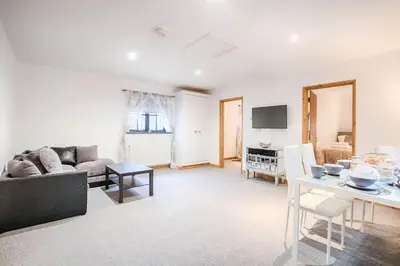 a living room with a couch and a table at Highgate Annexe in Takeley