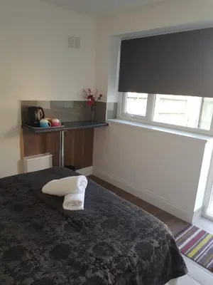a bedroom with a bed and a window with a window shade at Stanwell Stansted Airport in Takeley