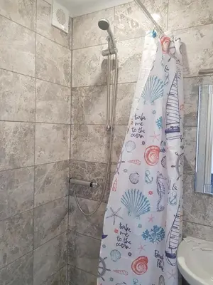 a shower with a shower curtain in a bathroom at Stanwell Stansted Airport in Takeley