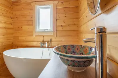 a bathroom with a tub and a sink at The Lodge in Stowmarket