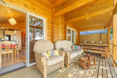 a porch of a cabin with wicker chairs and a table at The Lodge in Stowmarket
