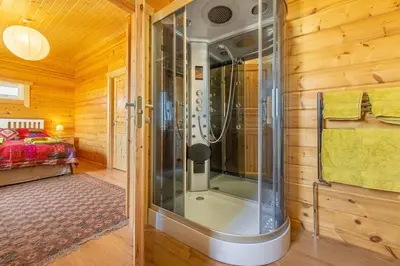 a glass shower in a room with a bedroom at The Lodge in Stowmarket