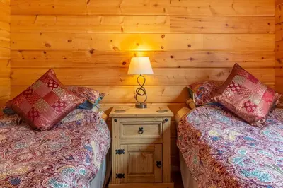 a bedroom with two beds and a lamp on a night stand at The Lodge in Stowmarket