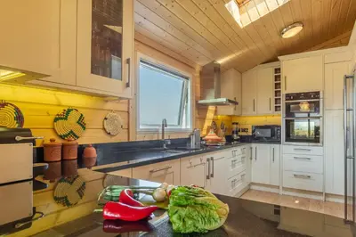 a kitchen with white cabinets and vegetables on a counter at The Lodge in Stowmarket