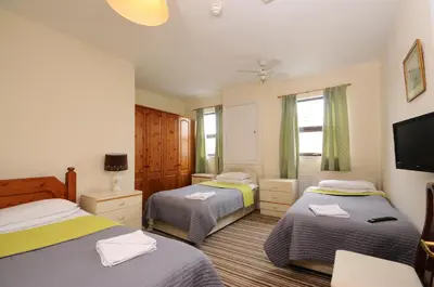 a bedroom with two beds and a flat screen tv at The Rathmore in Cambridge