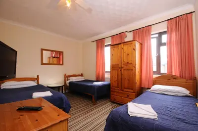 a hotel room with two beds and a television at The Rathmore in Cambridge