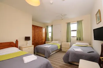 a bedroom with two beds and a flat screen tv at The Rathmore in Cambridge