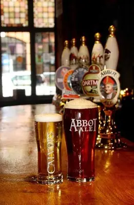 two glasses of beer sitting on a wooden table at The Griffin Hotel in Attleborough