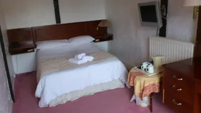 a bedroom with a bed with two towels on it at The Griffin Hotel in Attleborough