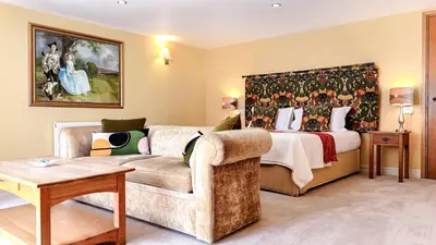a living room with a couch and a bed at The Pheasant Public House & Hotel in Gestingthorpe