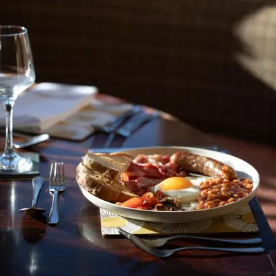 a plate of food with an egg and bread on a table at The Pheasant Public House & Hotel in Gestingthorpe