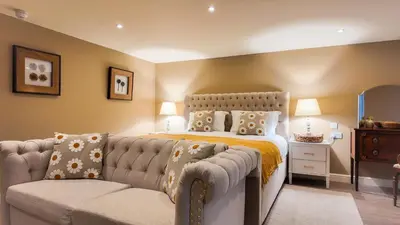 a bedroom with a bed and a couch at The Pheasant Public House & Hotel in Gestingthorpe