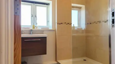 a bathroom with a shower and a sink at The Pheasant Public House & Hotel in Gestingthorpe