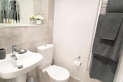 a bathroom with a white toilet and a sink at Citystay Living - Midsummer Mews in Cambridge