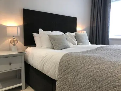 a bedroom with a large bed with a black headboard at Citystay Living - Midsummer Mews in Cambridge