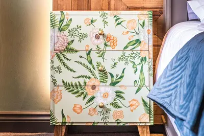 a bedroom with a floral patterned chair next to a bed at The Cricketers Clavering in Clavering