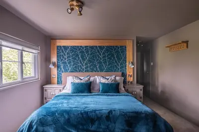 a bedroom with a blue bed with two blue pillows at The Cricketers Clavering in Clavering