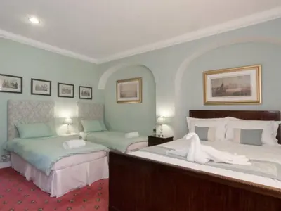 a bedroom with two beds and two lamps at Hockwold Hall in Hockwold cum Wilton