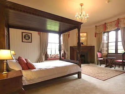 a bedroom with a canopy bed and a table and chairs at Hockwold Hall in Hockwold cum Wilton