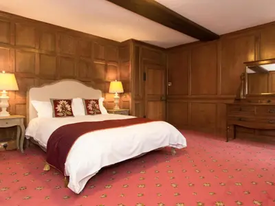 a large bedroom with a large bed and a dresser at Hockwold Hall in Hockwold cum Wilton