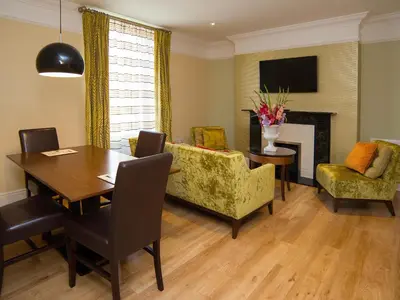 a dining room with a table and chairs and a fireplace at Lensfield Hotel in Cambridge