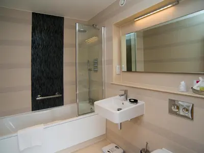 a bathroom with a sink and a shower and a mirror at Lensfield Hotel in Cambridge