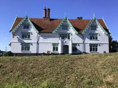 a large white house sitting on top of a hill at Owl's Hoot in Thorndon