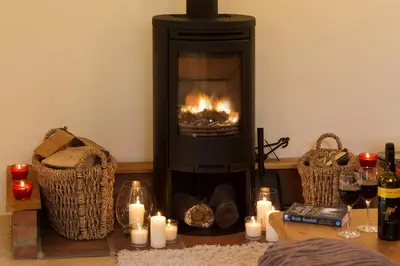 a fireplace with candles and wine glasses on a table at Owl's Hoot in Thorndon