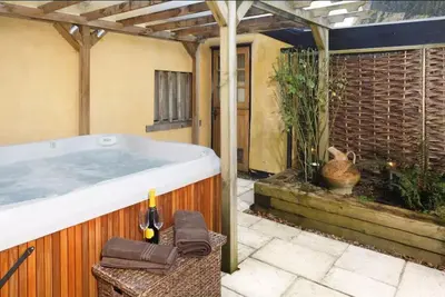 a bathroom with a hot tub in a building at Oak Cottage in Thorndon