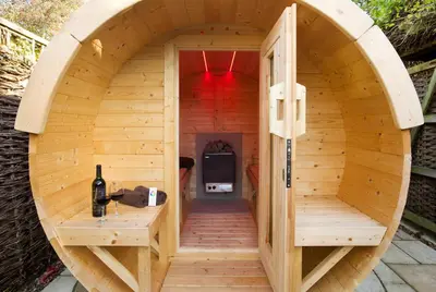a wooden sauna with a circular opening in the middle at Oak Cottage in Thorndon
