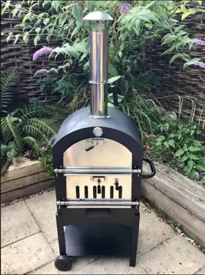 a black and white stove sitting in a garden at Oak Cottage in Thorndon