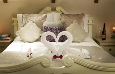 two swans made out of towels on a bed at Honeysuckle Cottage in Thornham Magna